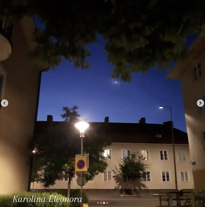 Bostadsområde med ett 7D Pleiadian skepp som fotats emot blå kvällshimmel