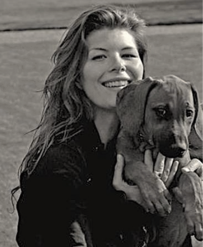 En helande kvinna som håller i en hund i svartvitt, en symbol för Karolina Eleonoras populära energihealing behandlingar.