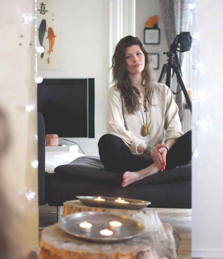 En kvinna sitter framför en spegel, hon är emotion code healer Karolina Eleonora