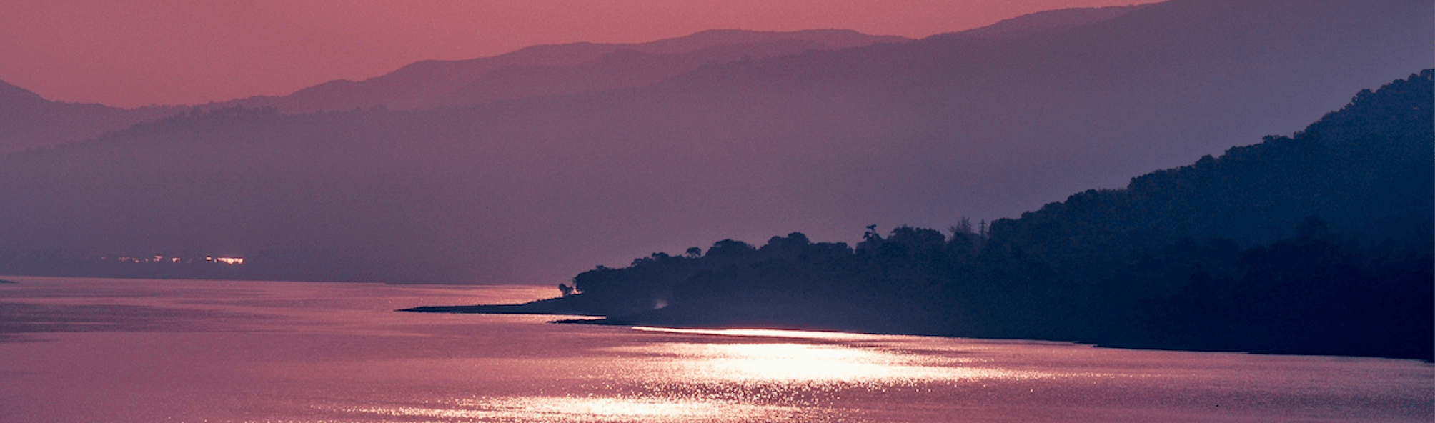 Rosa solnedgång över vatten, en symbol för Emotion Code healing behandling av Karolina Eleonora