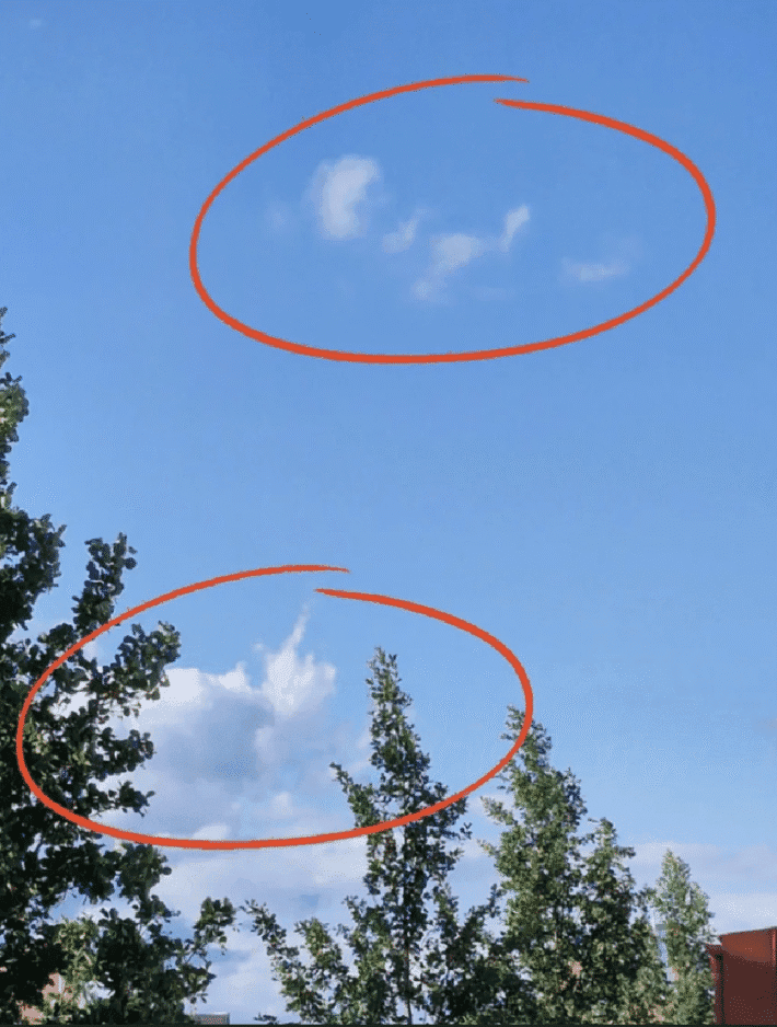 Blå himmel med moln liknande en hand som pekar på en bebis.